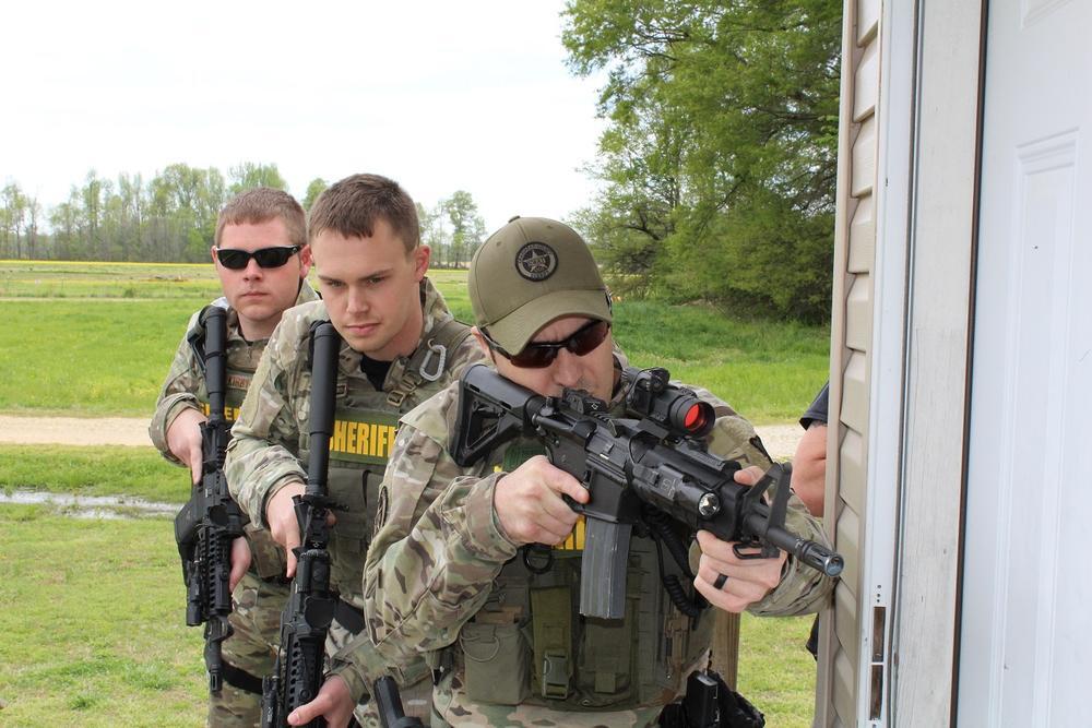 Special Response Team member looking around corner of a building