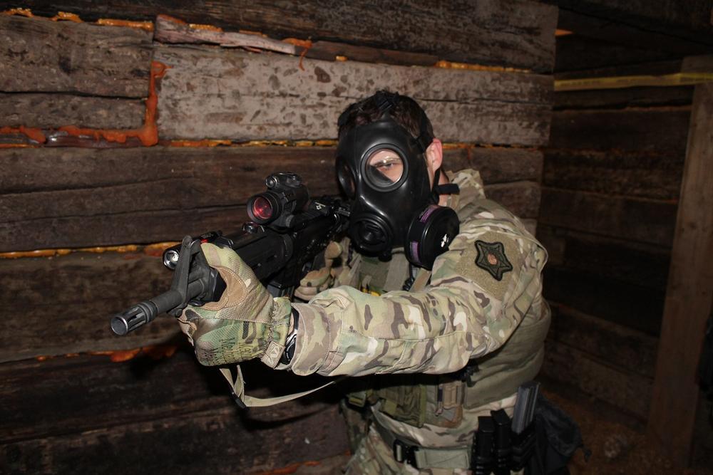 Special Response Team member wearing gas mask with gun drawn